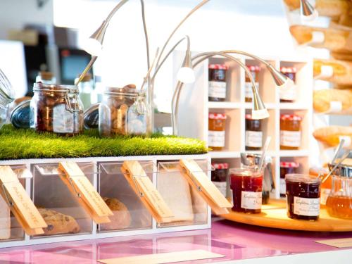 a display case in a bakery with jars of food at Novotel Lille Centre Gares in Lille