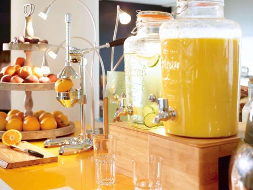 a table with a jar of orange juice on it at Novotel Lille Centre Gares in Lille
