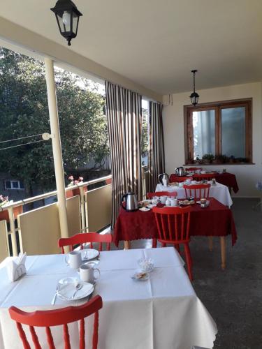 una fila de mesas con sillas rojas en un restaurante en Omsi House, en Telavi