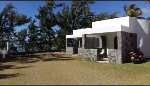 a house with a motorcycle parked in front of it at Le Shanoa in Rodrigues Island