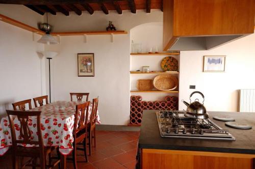 a kitchen with a stove and a table with chairs at Fattoria di Fubbiano in Collodi