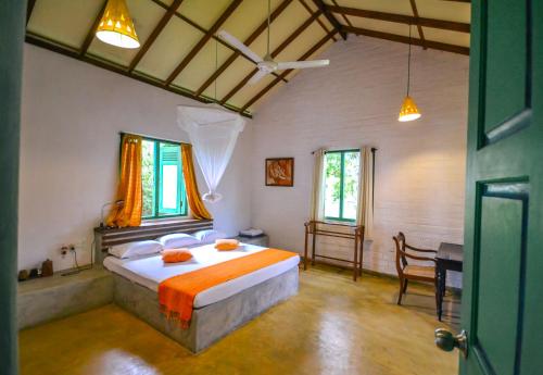 a bedroom with a bed and a desk in it at Back of beyond - Wellness Retreat in Tangalle