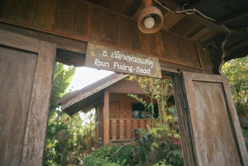 a sign on the door of a wooden building at Phuruarounmai Organic Living Resort in Loei