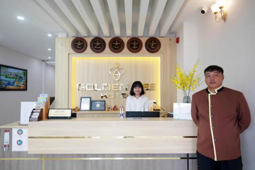 a man standing in front of a counter in a store at Golden Bee Hotel in Da Lat