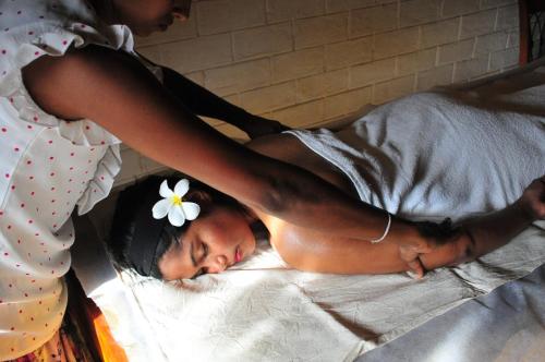 a woman is giving a man a flower on a bed at Back of beyond - Wellness Retreat in Tangalle