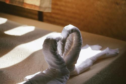 a towel forming the shape of a heart on a bed at Phuruarounmai Organic Living Resort in Loei
