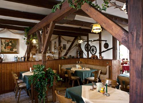 a restaurant with tables and chairs with green table cloth at Hotel Lindenhof in Bad Lauchstädt