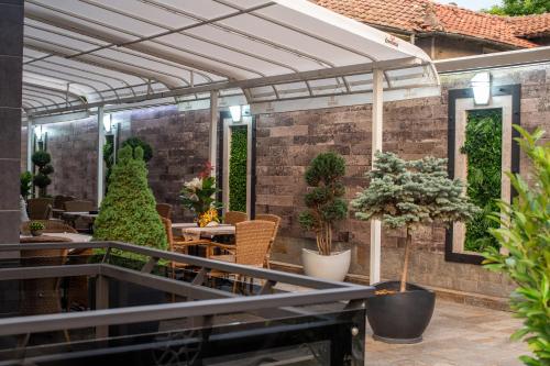 an outdoor patio with plants and a pergola at Hotel Idol in Targovishte