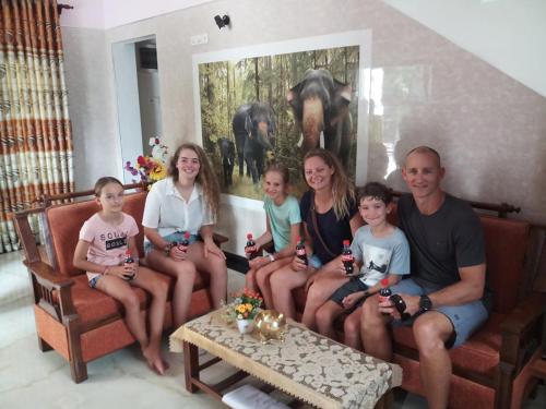 a family sitting on a couch in a living room at House of Richness in Negombo