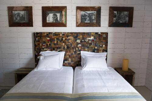 two beds in a room with pictures on the wall at Surfers Lodge Peniche in Peniche