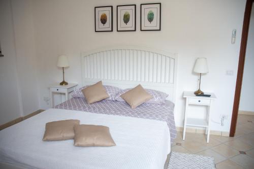 1 dormitorio con 1 cama blanca grande y 2 mesas en Scalinatella en Positano