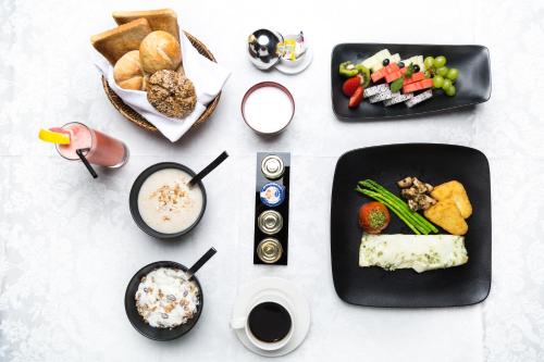 a table with plates of food and other foods at Mercure Dubai Barsha Heights Hotel Suites And Apartments in Dubai