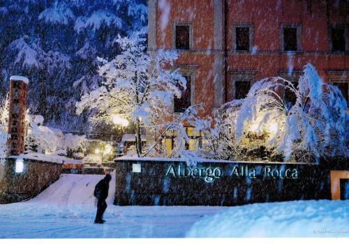 a man riding a skateboard down a snow covered street at Alla Rocca Hotel Conference & Restaurant in Bazzano