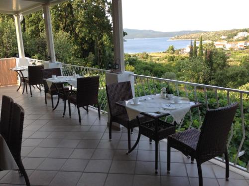 a restaurant with tables and chairs on a balcony at Vila Mozara in Slano