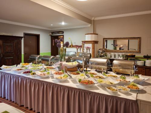 a table filled with bowls and plates of food at Hotel Gasthaus zur Linde in Seevetal