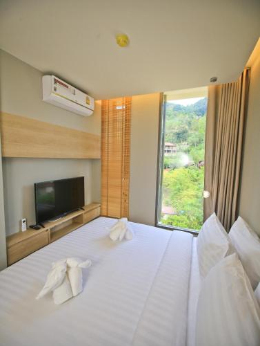 a hotel room with a bed with towels on it at Rocco Aonang Krabi in Ao Nang Beach