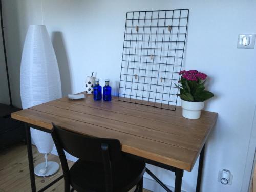 a wooden table with blue bottles and flowers on it at Villa des Contamines in Crémieu