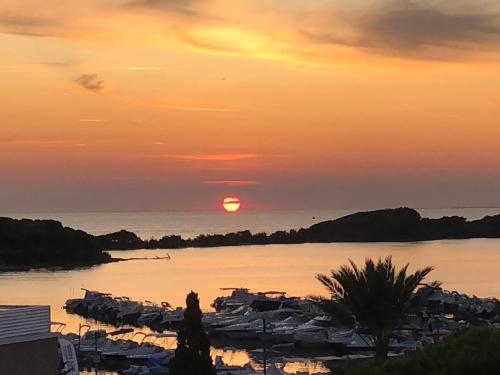een zonsondergang boven een waterlichaam met boten bij Casa vacanze Santa Lucia in Porto Cesareo