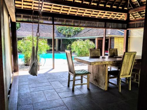 a dining room with a table and chairs on a patio at Pool Mountain Moorea in Moorea