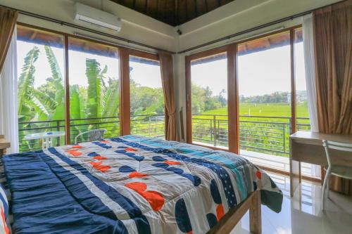 a bedroom with a bed in a room with windows at Sunari Guest House in Canggu