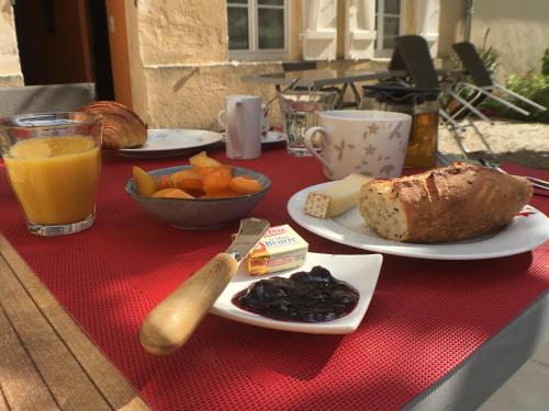 uma mesa com pratos de comida numa toalha de mesa vermelha em Domaine de Ludeye em Listrac-Médoc