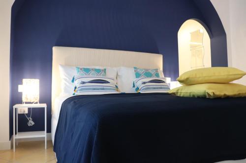 a blue bedroom with a bed with pillows on it at Lemon Suite in Naples