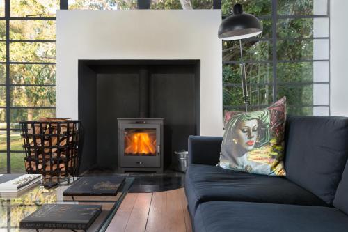 a living room with a couch and a fireplace at Bloomestate Swellendam in Swellendam