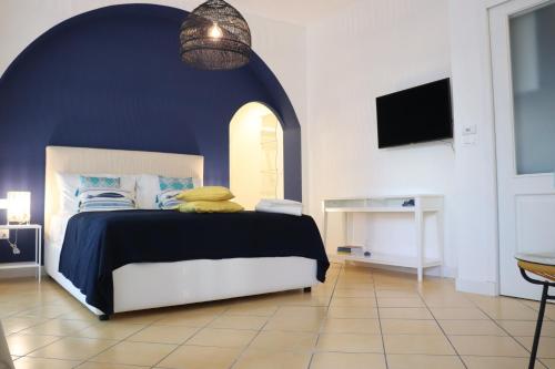 a bedroom with a bed with a blue wall at Lemon Suite in Naples