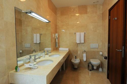 a bathroom with two sinks and a toilet at INATEL Vila Ruiva in Vila Ruiva