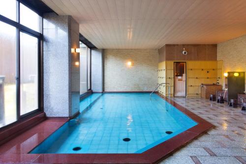 uma piscina num quarto com uma grande janela em Yamanaka Onsen Kissho Yamanaka em Kaga