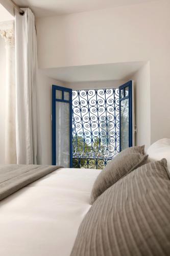 a bedroom with a bed and a window at La Villa Bleue-Sidi Bou Said in Sidi Bou Saïd