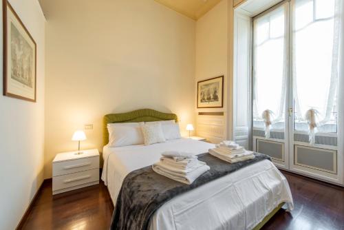 1 dormitorio con cama y ventana grande en Milan Royal Suites - Centro Cadorna, en Milán