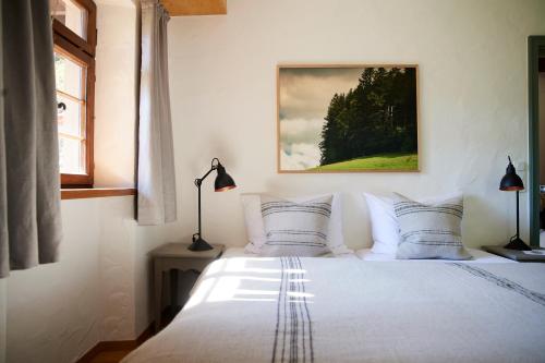 a bedroom with a bed with white sheets and pillows at Hotel & Restaurant Linde in Münstertal