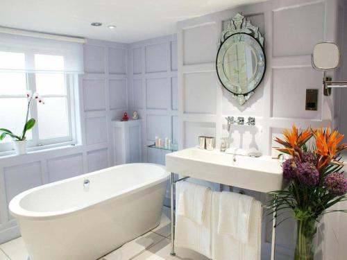 a bathroom with a tub and a sink and a mirror at The Black Horse Fulmer in Fulmer