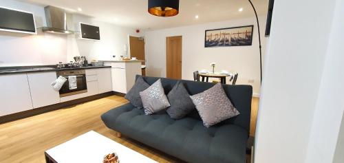 a living room with a couch and a kitchen at Northampton 2 Bedroom Town Centre Apartment close to University, Hospitals, Brackmills in Northampton
