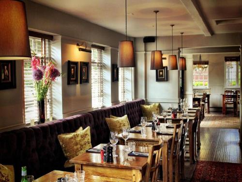 a restaurant with tables and chairs and a couch at The Black Horse Fulmer in Fulmer
