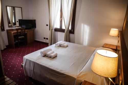a hotel room with a bed with towels on it at VILLANOVA HOTEL in San Bonifacio