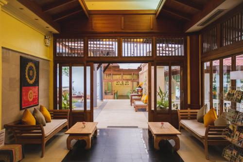 a lobby with benches and tables in a building at Ma Doo Bua Stay - SHA Extra Plus in Thalang