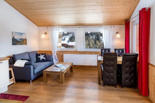 a living room with a blue couch and a table at Apartment Turmzimmer in Langwies