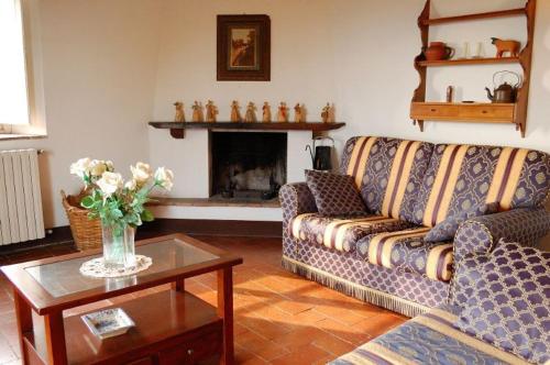 a living room with a couch and a fireplace at Fattoria di Fubbiano in Collodi