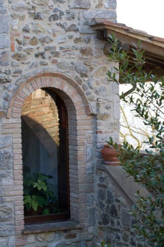 an archway in a brick building with a window at Sant'Antonio in Volterra