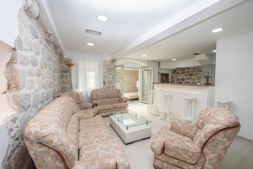 a living room with two couches and a fireplace at Apartment Kula Đurišić in Perast