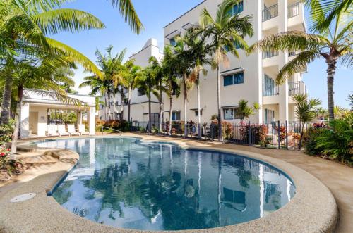 a large swimming pool in front of a large building at Madison Ocean Breeze Apartments in Townsville