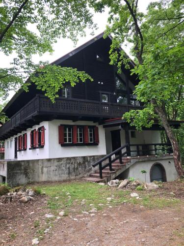 a house with red windows and a balcony at House of Finn Juhl Hakuba in Hakuba