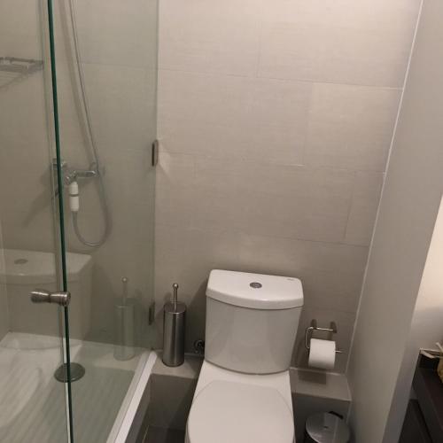 y baño pequeño con aseo y ducha. en Kennedy Premium Apartments Colorado, en Santiago