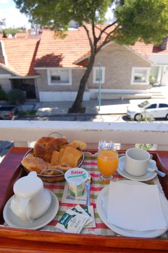 a tray of breakfast food on a table with orange juice at Hosteria Lucky Home in Mar del Plata