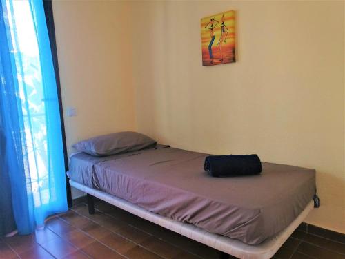 a small bed in a room with a bag on it at Bungalow in Altamar complex in Arona