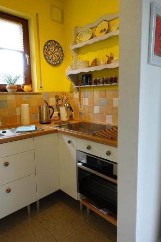 a kitchen with yellow walls and a stove top oven at Kleines Refugium in Bad Sachsa