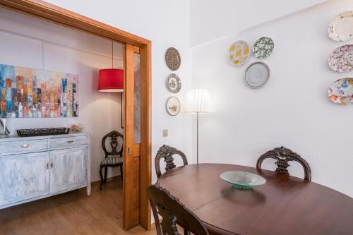 a dining room with a table and plates on the wall at Sons do Mar - Charming Apartment by the Sea in Armação de Pêra