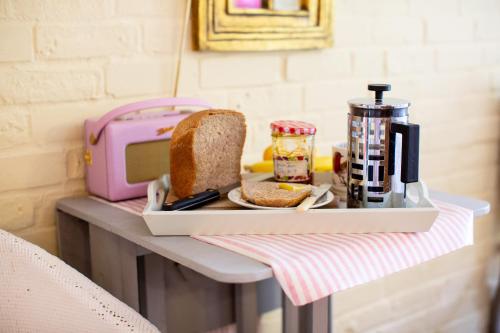 a tray with a loaf of bread on a table at Cosy Cottage ground floor bedroom ensuite with private entrance in Chichester